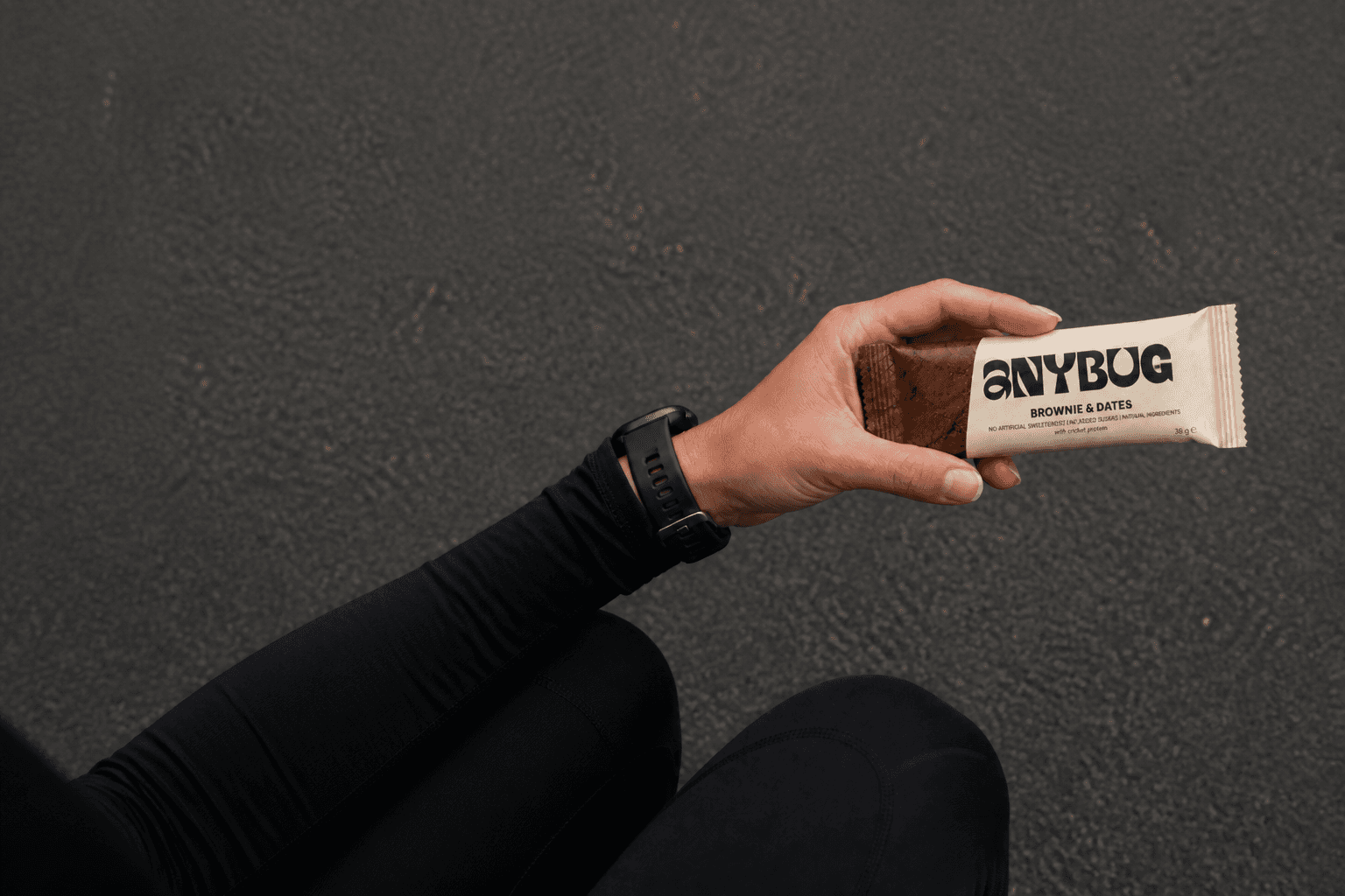 Mano sujetando una barrita AnyBug Brownie & Dates tras salir a correr